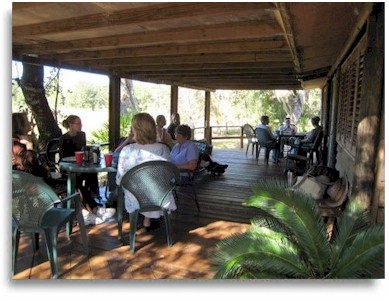 Group sharing a meal on the porch at Rasayana Cove Ayurvedic Retreat